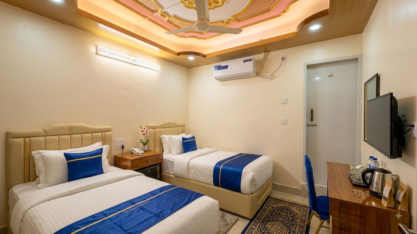 Une chambre d’hôtel avec deux lits, un bureau, une télévision et un ventilateur de plafond.