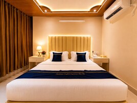 Habitación de hotel con una cama grande, una mesita de noche con lámpara y aire acondicionado instalado en la pared.