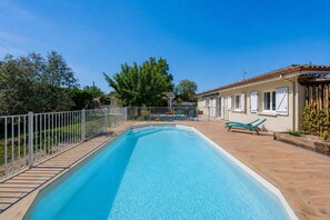 A rectangular swimming pool with a wooden deck, a white fence, and two blue lounge chairs. - La Bohème du Lac - Maison climatisée avec piscine (La Teste-de-Buch)