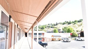 A covered outdoor area with a row of windows and a building labeled "HARDWARE" in the background. - Arlington inn (Arlington)