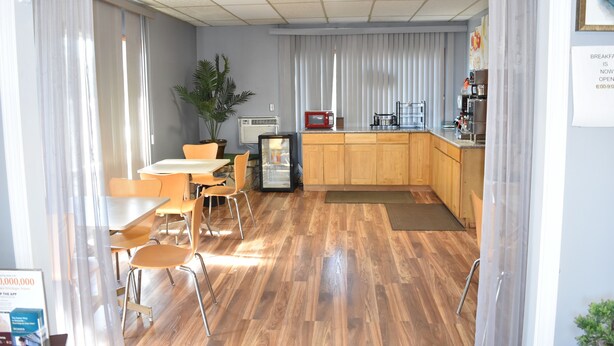 A room with a dining area, a kitchenette, and a large window with curtains. - Arlington inn (Arlington)