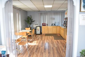 A room with a dining area, a kitchenette, and a large window with curtains. - Arlington inn (Arlington)