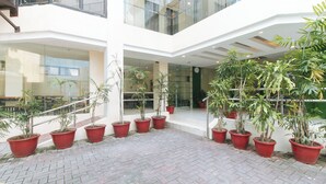 A modern building with a courtyard featuring potted plants and a brick floor. - UrbanViewSanAntonio'sPlaceSampalocManila (Manila)