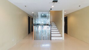 A modern interior with a staircase, a glass partition, and a ceiling-mounted security camera. - UrbanViewSanAntonio'sPlaceSampalocManila (Manila)