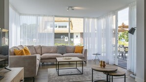 Una sala de estar moderna con un sofá, una mesa de centro y un mueble para televisión.
