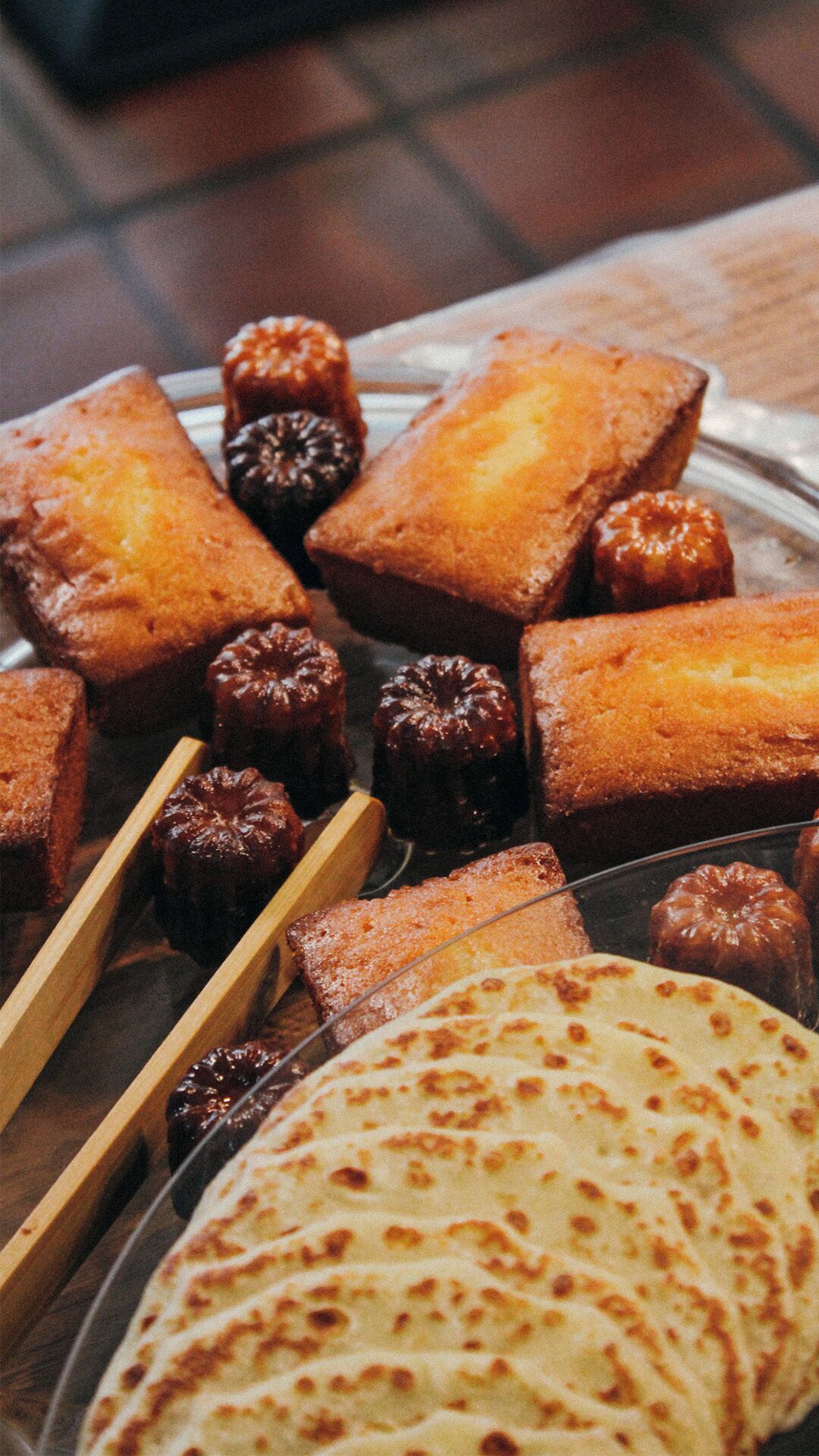 Diversos pães achatados e doces em uma bandeja.
