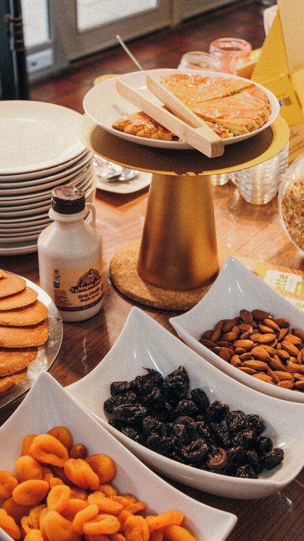 A breakfast buffet with various food items, including pastries, fruits, and a bottle of syrup. - hotel la belle poule  (Rochefort)