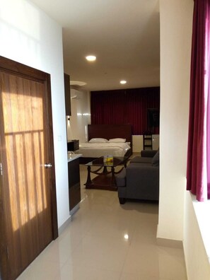 Ein Hotelzimmer mit Bett, Sofa, kleinem Tisch und Fernseher.