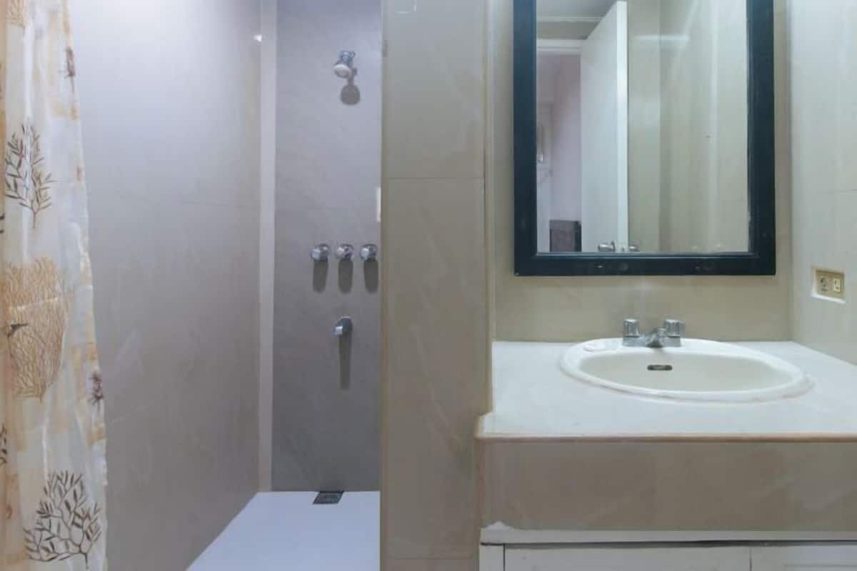 A bathroom with a shower, a sink, and a mirror.