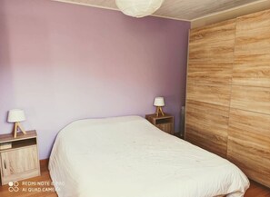 2 dormitorios y tabla de planchar con plancha