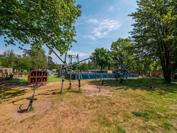 A playground with various play structures including swings and climbing frames.
