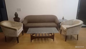 A living room with a sofa, two armchairs, and a coffee table.