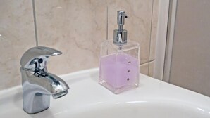 A bathroom sink with a chrome faucet and a clear soap dispenser with a purple liquid. - Beachfront Apartments Tamarix - Studio Apartment 3 (Posedarje)