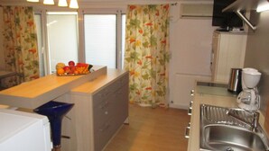 A compact kitchen with a central island, a sink, and a microwave. - Guest House Villa Daniel - Two Bedroom Apartment with Balcony (Omis)