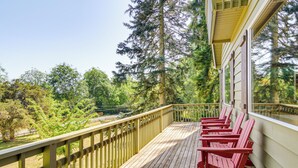A wooden deck with red Adirondack chairs, overlooking a forested area. - Langley Forest Cabin w/ Grill < 2 Mi to Downtown! (Langley)
