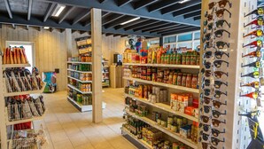 A grocery store with shelves stocked with various food items and a display of sunglasses. - Captivating Chalet Near Amsterdam (Amstelveen)