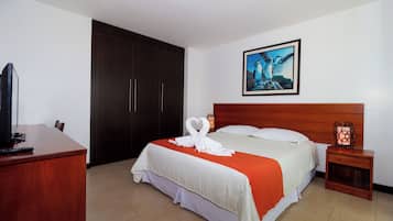 A hotel room with a bed, a desk, a TV, a wardrobe, and a painting on the wall.