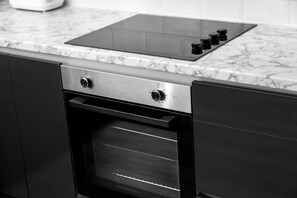 A kitchen with a built-in oven and a stovetop. - Modern 2 Bed Apartment - Smart TV - WIFI -  Jewellery Quarter (Birmingham)