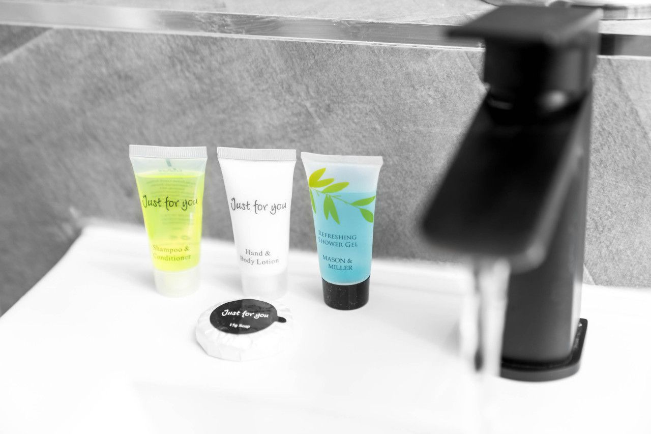Trois produits de soins personnels sont posés sur le comptoir d’une salle de bain.