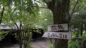 Ein hölzernes Wegweiser mit japanischen Schriftzeichen und der Nummer '209-211', der einen Ort oder eine Route kennzeichnet.