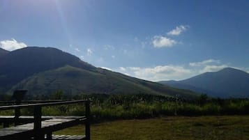Un pontile di legno con vista su una catena montuosa sotto un cielo sereno.