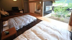Une chambre d’hôtel avec deux lits, une télévision et vue sur le jardin.