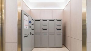 A narrow hallway with lockers and a control panel on the left. - HanTing Hotel (Guangzhou Tianhe Bus Station) (Guangzhou)