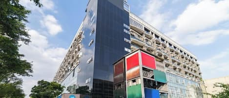 A multi-story building with a modern glass facade, a parking garage, and various commercial spaces on the ground floor.