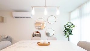 Un comedor moderno con una mesa de mármol, tres sillas y una planta.