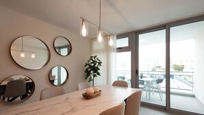 Un comedor moderno con una mesa de mármol, sillas redondas y un amplio ventanal con vistas a la ciudad.