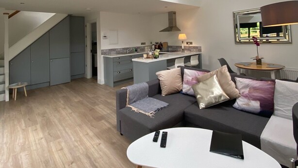 A spacious living area with a modern kitchen, a dining area, and a staircase leading to an upper level. - Delightful studio with WiFi in Ballyvaughan (Ballyvaughan)