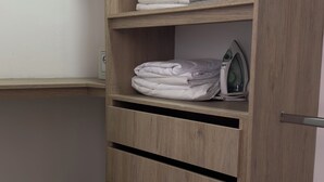A wooden wardrobe with multiple shelves, some containing folded clothes and a kettle. - Hermoso Apartamento en la mejor ubicacion by Hoost 610 (Medellín)