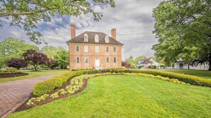 A large brick building with a symmetrical facade, multiple chimneys, and a central entrance. - Step into Colonial Charm at The Historic Powhatan Resort in Williamsburg - 2 Bd. (Williamsburg)