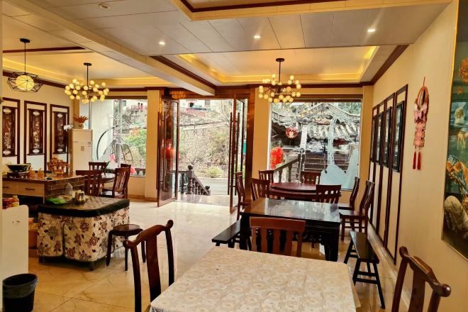 A dining area with a central table, chairs, and a kitchen counter.