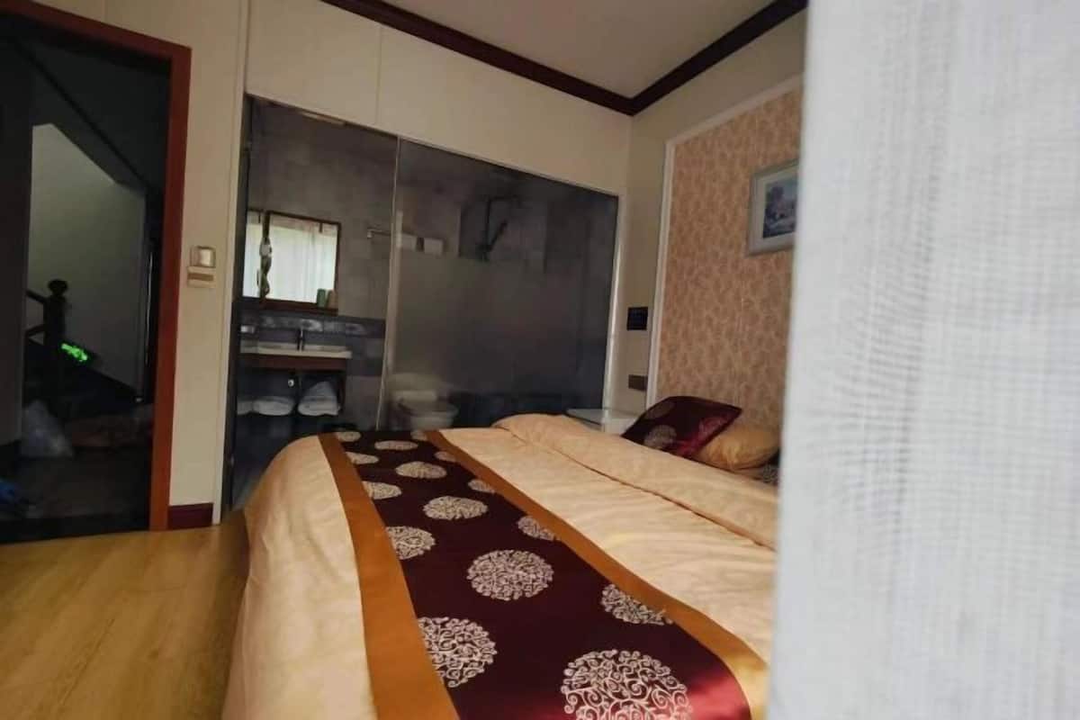 A bedroom with a bed, a wardrobe, and a bathroom.