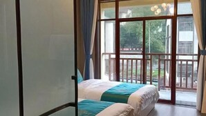 A room with two beds, a balcony with a railing, and a view of the outdoors. - Damingshan Juxianlou Homestay (Hangzhou)