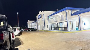 A commercial building with a sign reading "Dreamland Fitness Centers" and a parking lot with several vehicles. - Dreamland Inn and Suites (Senatobia)