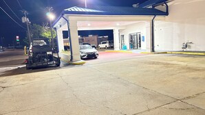 A gas station with a canopy, a white car, and a three-wheeled vehicle parked under it. - Dreamland Inn and Suites (Senatobia)