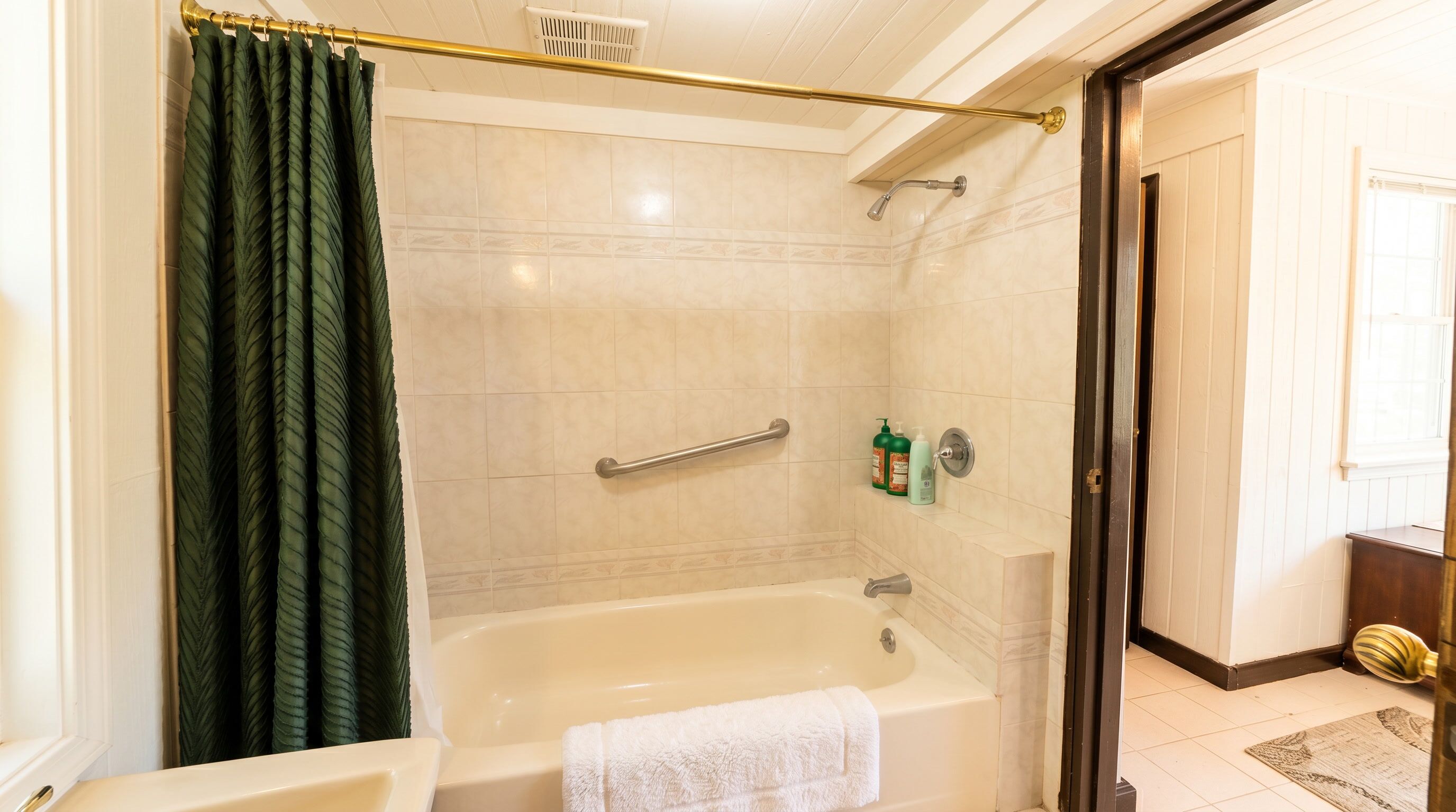 A bathroom with a bathtub, shower, and toilet.