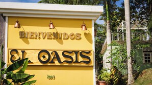 A yellow sign with "BIENVENIDOS EL OASIS" and the year "1993". - El Oasis Hotel (Aguada)