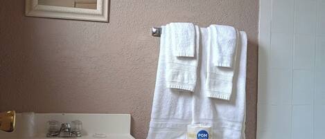 Een badkamer met een witte wastafel, spiegel, toilet en bad.