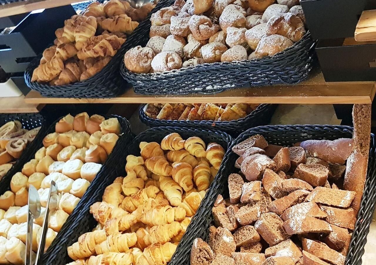 A display of various baked goods including pastries and bread.