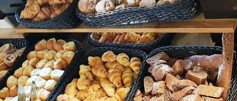 Une présentation de divers produits de boulangerie, notamment des pâtisseries et du pain.