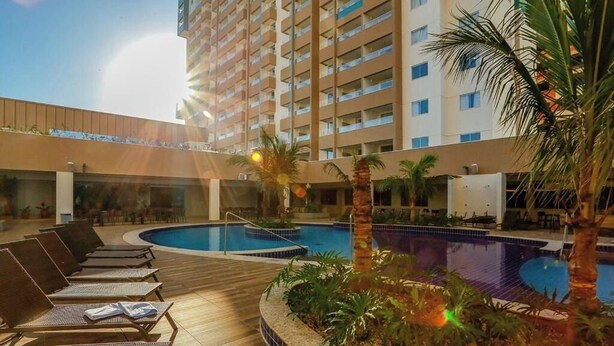 A hotel pool area with sun loungers and palm trees. - Olímpia Park Resort Reserve Temporada (Olímpia)