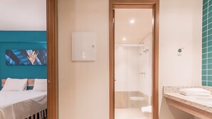 A hotel room with a bed, a shower, and a bathroom with a sink and mirror. - Olímpia Park Resort Reserve Temporada (Olímpia)