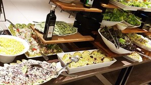 A buffet with various dishes including salads, a bottle of wine, and a variety of side dishes. - Olímpia Park Resort Reserve Temporada (Olímpia)
