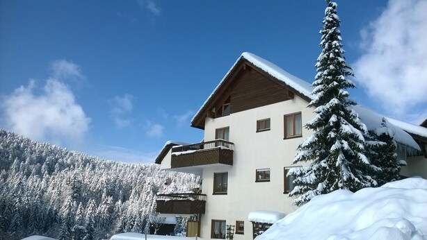 A multi-story building with a balcony, surrounded by snow-covered trees and a clear sky. - Schöne, große, barrierefreie Ferienwohnung, ruhig, idyllisch, familienfreundlich (Todtmoos)