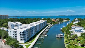 Ein modernes Hotel mit einer Marina, das einen weiten Blick auf das Wasser bietet, mehrere Terrassen und eine Anlegestelle für Boote.