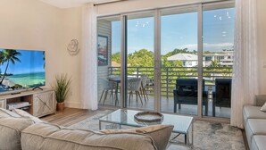 Ein Wohnzimmer mit einem großen Schiebeglastür, die auf eine Terrasse im Freien führt.