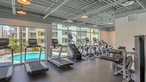 Ein Fitnessstudio mit Laufbändern, Crosstrainern und Gewichten.